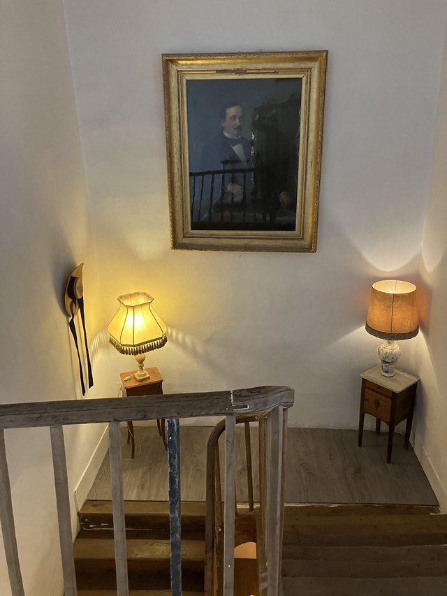 Landing of the central staircase, with antique portrait and period lamps