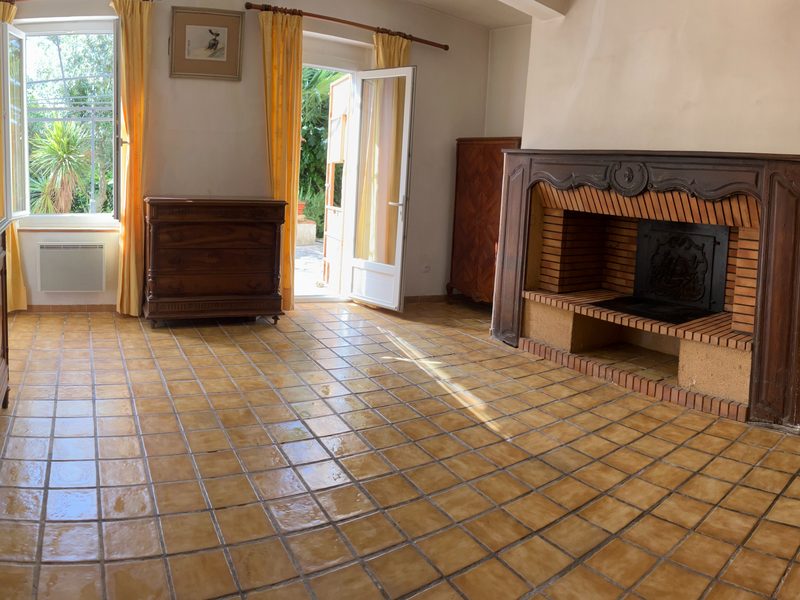 Dining room, second view: stone and brick fireplace and French doors opening onto the garden