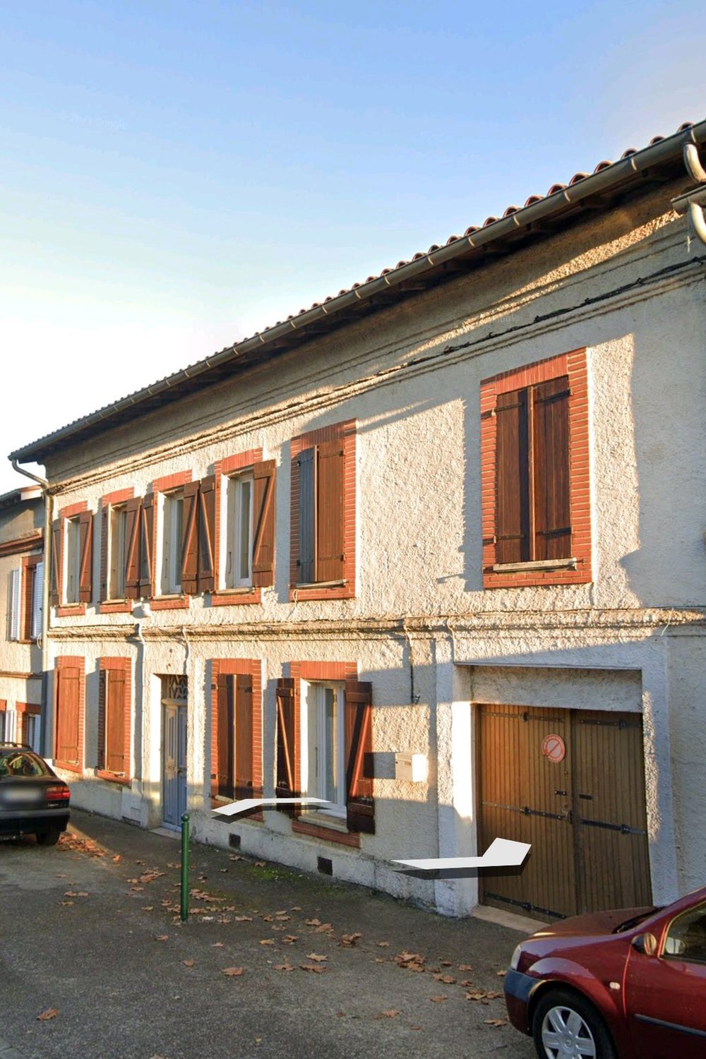 Façade de la maison côté rue, avec le garage intégré