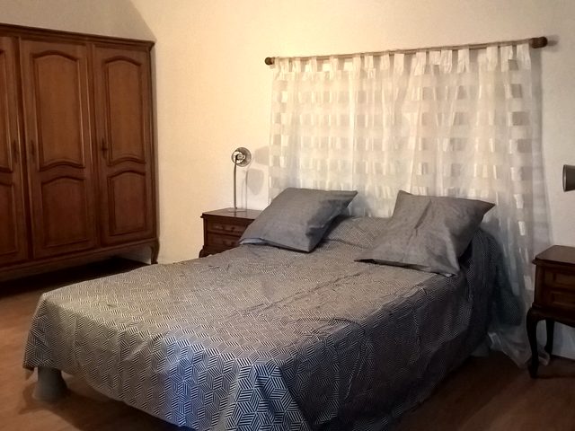 Chambre à l’étage côté rue, avec poutres apparentes et beau volume