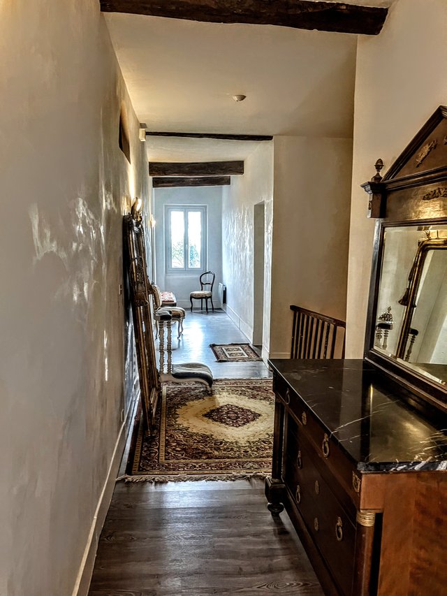 Couloir principal de l’étage côté rue, commode ancienne à dessus de marbre, miroir et parquet
