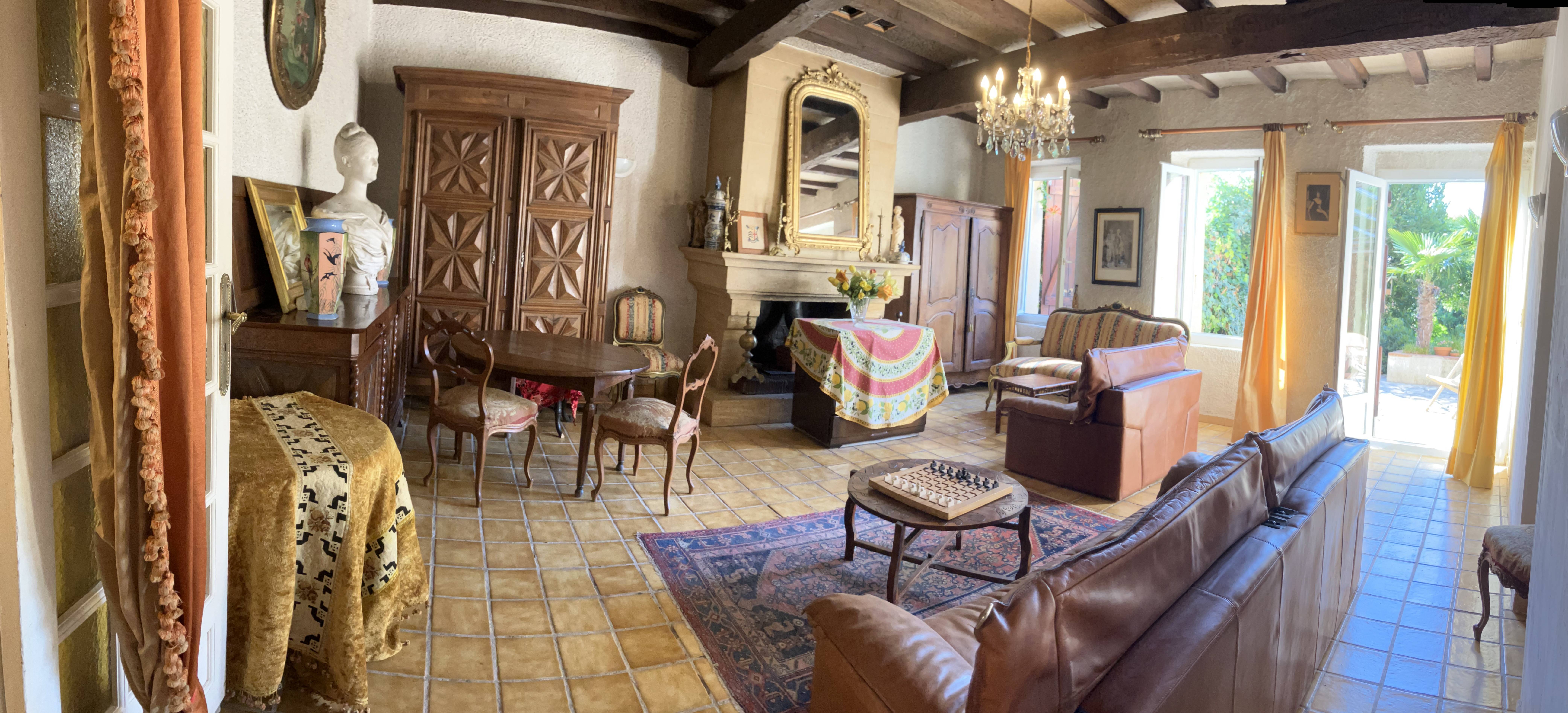 Le grand salon avec cheminée et poutres de la maison de caractère, près de Toulouse
